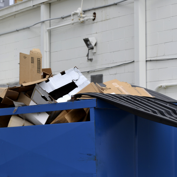 Renting a Dumpster for Your Small Business The Benefits etc - a blue dumpster with a cctv camera in the background