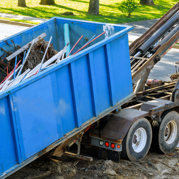 Renting a Dumpster for Your Small Business The Benefits, etc -  a blue roll-off dumpster being delivered 