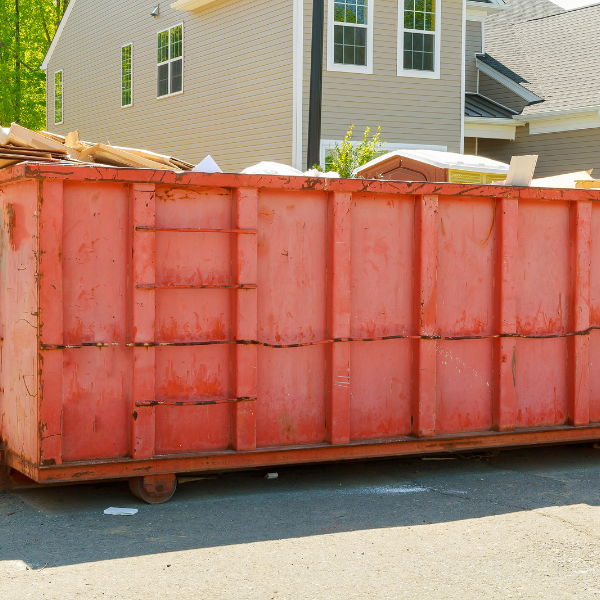 Renting a Dumpster for Your Small Business - The Benefits and Other Valuable Information - a faded red dumpster in a new housing area