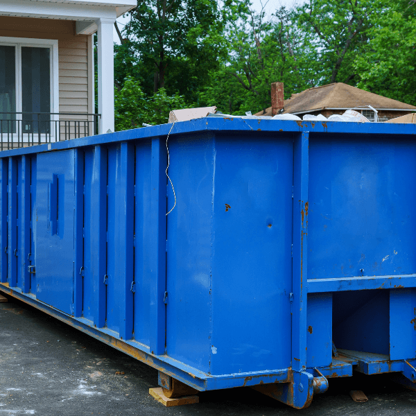 residential dumpster rental Canton GA - The Top 15 Reasons to Rent a Dumpster in Marrietta - blue dumpster that's nearly full in front of a house