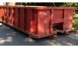 how much does a 10-yard dumpster rental cost - 10 Factors That Affect Dumpster Rental Rates - a long, red, and open dumpster in a driveway